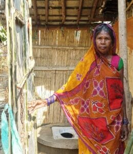 Lady showing off the new toilet for the Balwa Village Alive Project